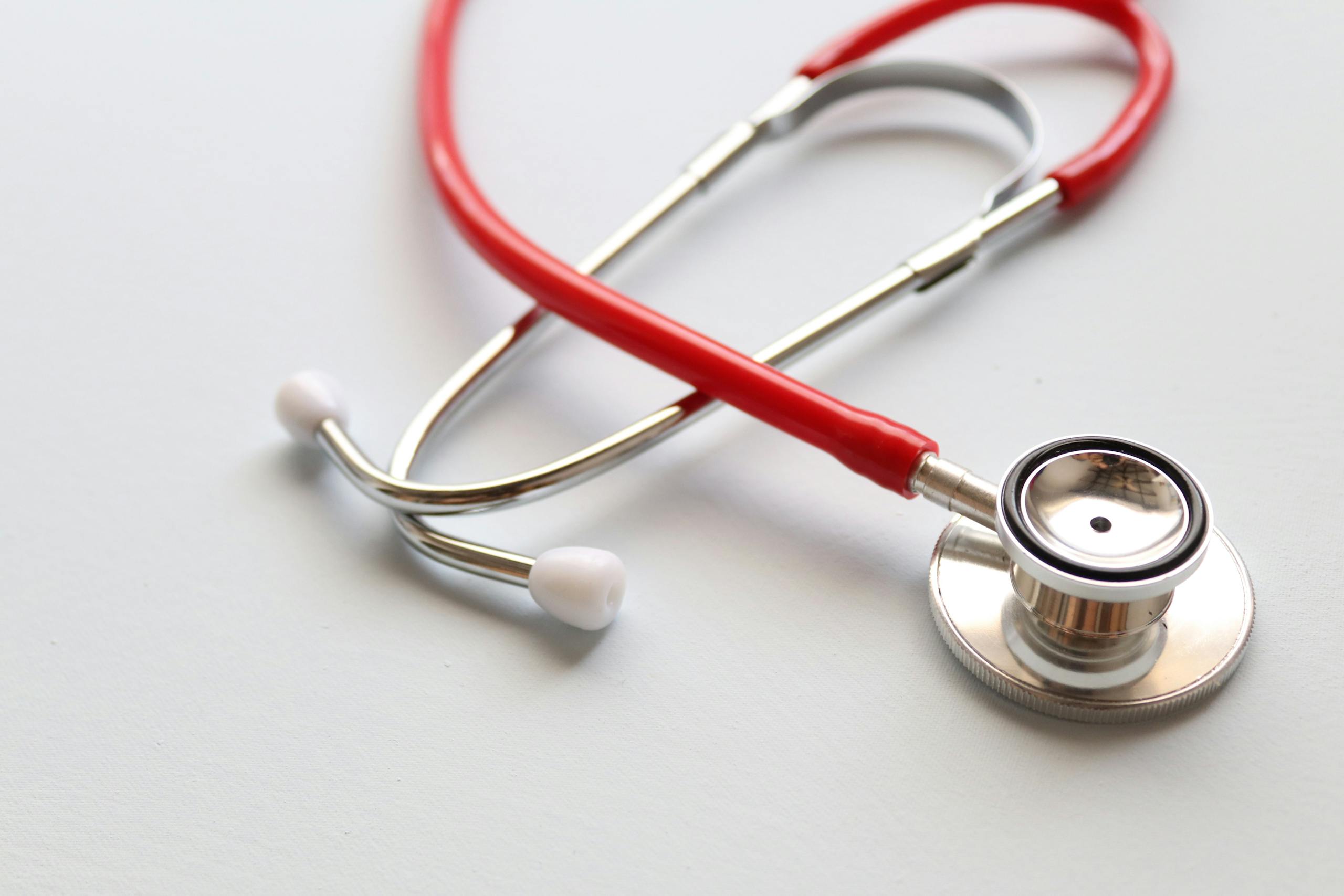Close-up of a red stethoscope symbolizing medical care and healthcare diagnostics.